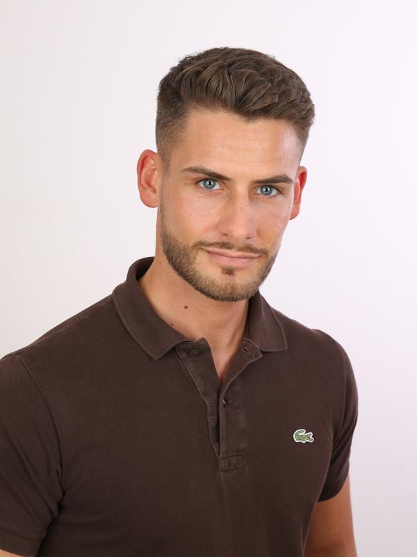Callboy Niclas von haut-nah.org im braunen Poloshirt mit seriösen Blick