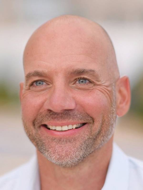 Male Escort Sascha from haut-nah.org, in the light blue shirt smiles sideways