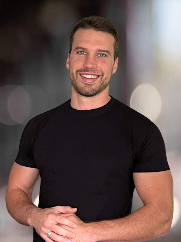 Callboy Sebastian von haut-nah.org mit schwarzen Shirt, lächelt geradeaus