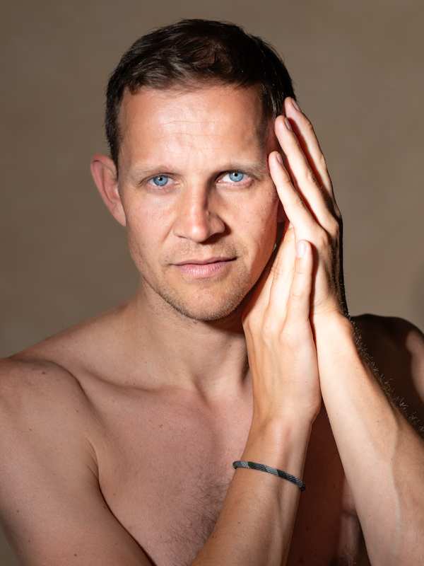 Escort Mann Anado von haut-nah.org freier Oberkörper mit Händen am Ohr