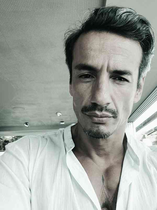 Escort Mann Cesar von haut-nah.org mit weissem Hemd schaut seriös