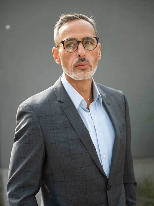 Escort Mann Rocco von haut-nah.org im Anzug mit Brille, seitlich, lässiger Blick