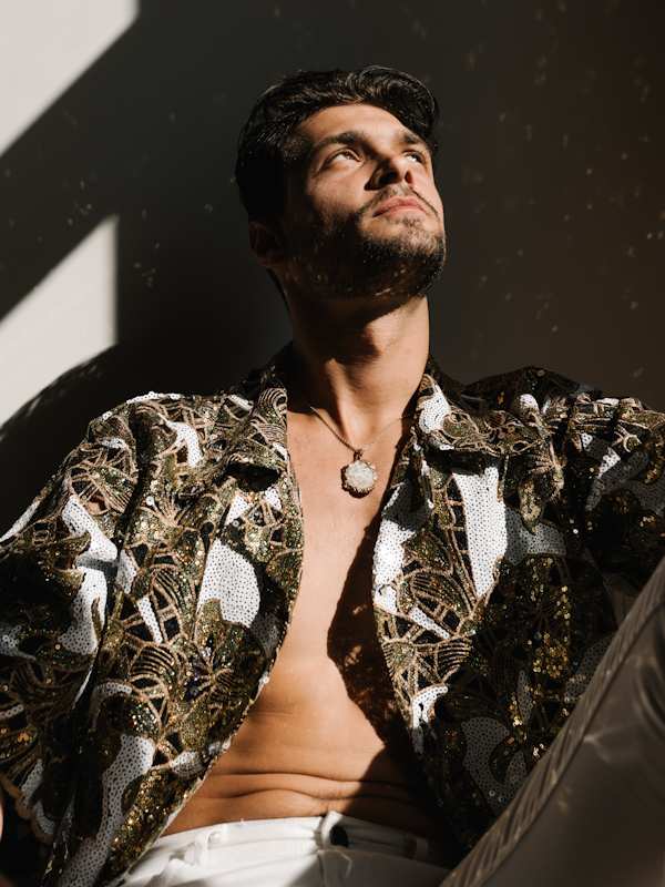 Escort Mann Noah von haut-nah.org im bunten Hemd schaut nach oben