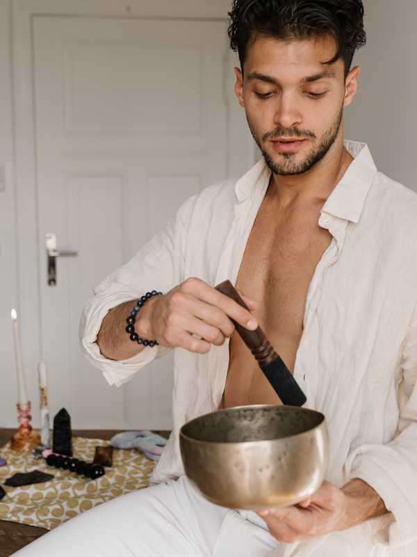 Escort Mann Noah von haut-nah.org mit Klangschale in weisser Stoffkleidung