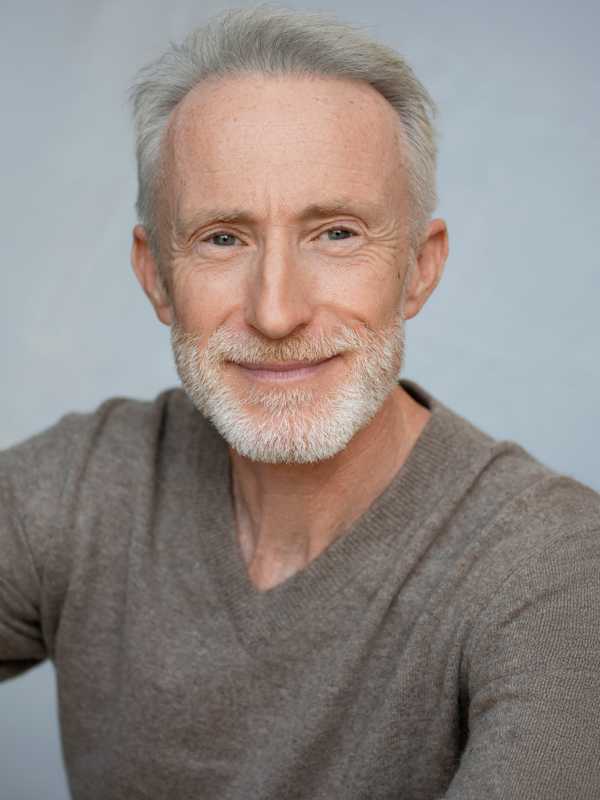 Escort Mann Robert von haut-nah.org im grauen Pulli, lächelt