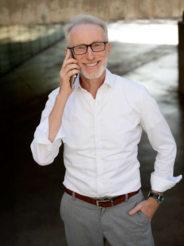 Escort Mann Robert von haut-nah.org im weißen Hemd, Handy am Ohr, lachend