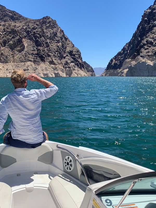 Callboy Maximilian von haut-nah.org sitzt am Bug eines Bootes vor einer Meerenge