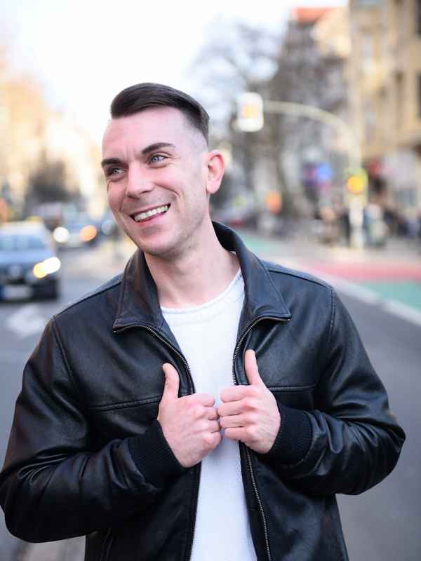 Escort Mann Dennis von haut-nah.org in Lederjacke mit City im Hintergrund