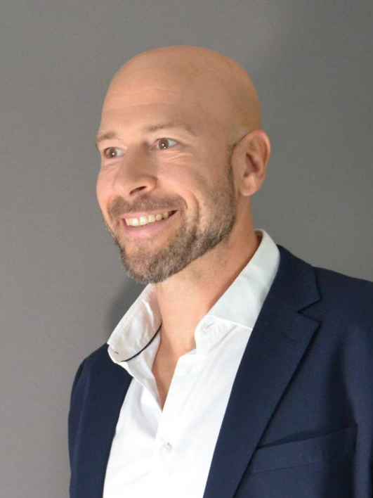 Escort Mann Stefan von haut-nah.org im blauen Anzug stehend mit seitlichen Blick