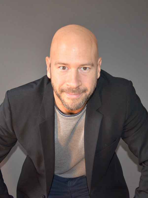 Escort Mann Stefan von haut-nah.org im schwarzen Sakko leicht nach vorne gebeugt