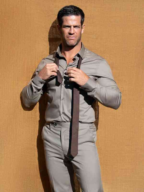 Male Escort Chris from haut-nah.org in anthracite shirt ties his tie