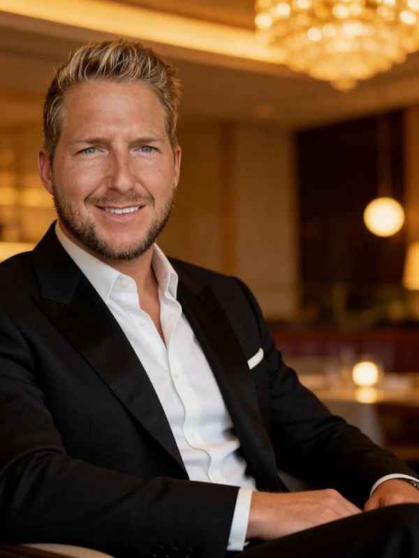 Escort Mann Maximilian von haut-nah.org mit schwarzen Anzug, weissen Hemd, in Hotellobby