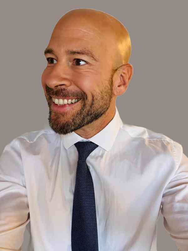 Male Escort Stefan from haut-nah.org in shirt and tie looks smiling to the side