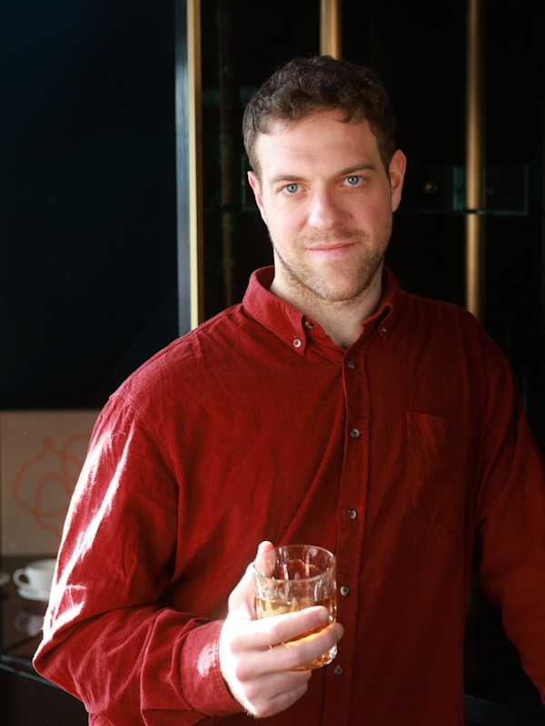 Callboy Simon von haut-nah.org mit roten Hemd und Drink in der Hand