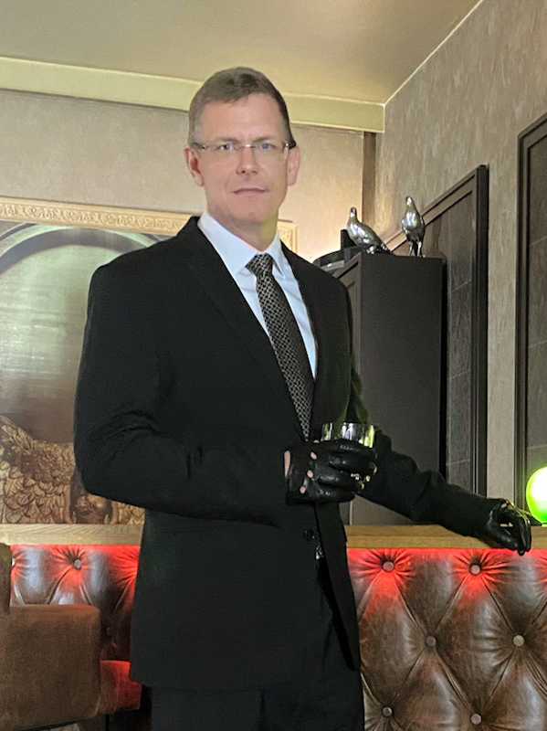 Escort Mann Alexander von haut-nah.org im Anzug und schwarzen Lederhandschuhen