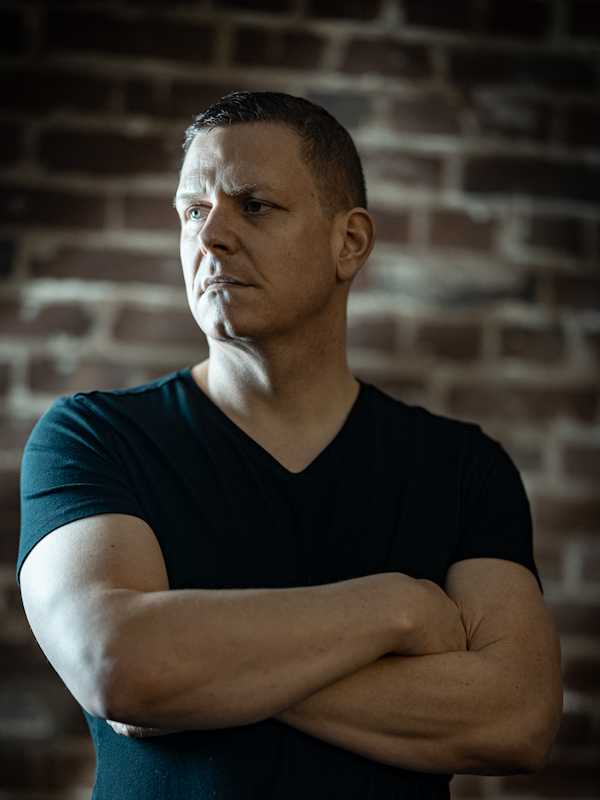 Escort Mann Alexander von haut-nah.org ohne Brille mit verschränkten Armen