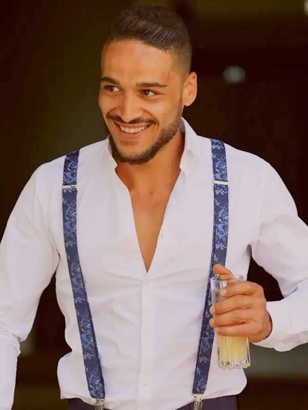 Escort Mann Johnny aus Karlsruhe von haut-nah.org lächelnd mit Hosenträger