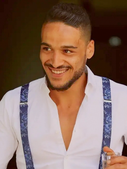 Escort Mann Johnny aus Karlsruhe von haut-nah.org lächelnd mit Hosenträger