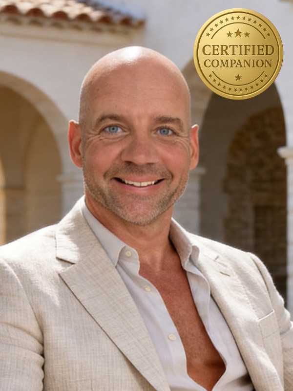 Escort Mann Sascha von haut-nah.org im Finca Innenhof, stilvoll gekleidet im Sitzen