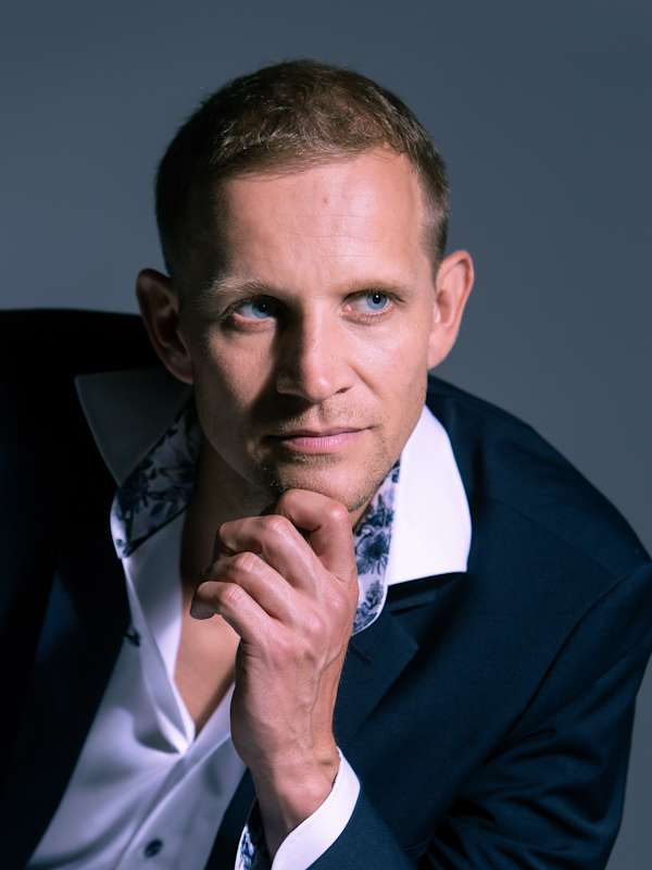 Callboy Anado von haut-nah.org, mit blauen Jacket schaut verführerisch zur Seite