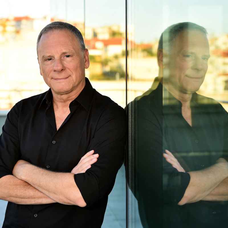 Callboy Stefan von haut-nah.org im schwarzen Hemd angelehnt an Glaswand auf Dachterrasse, Mediumshot